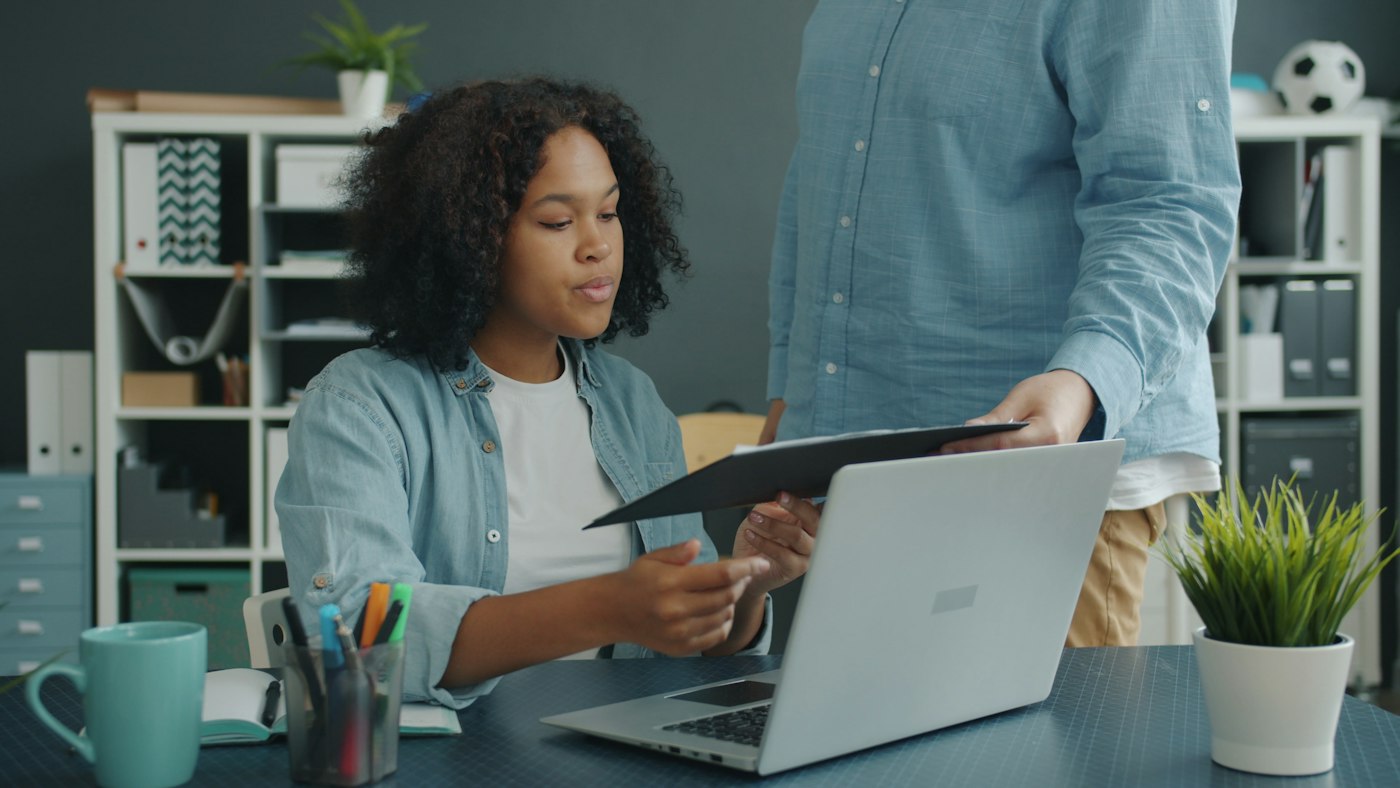 Two colleagues reviewing documents at an office desk
