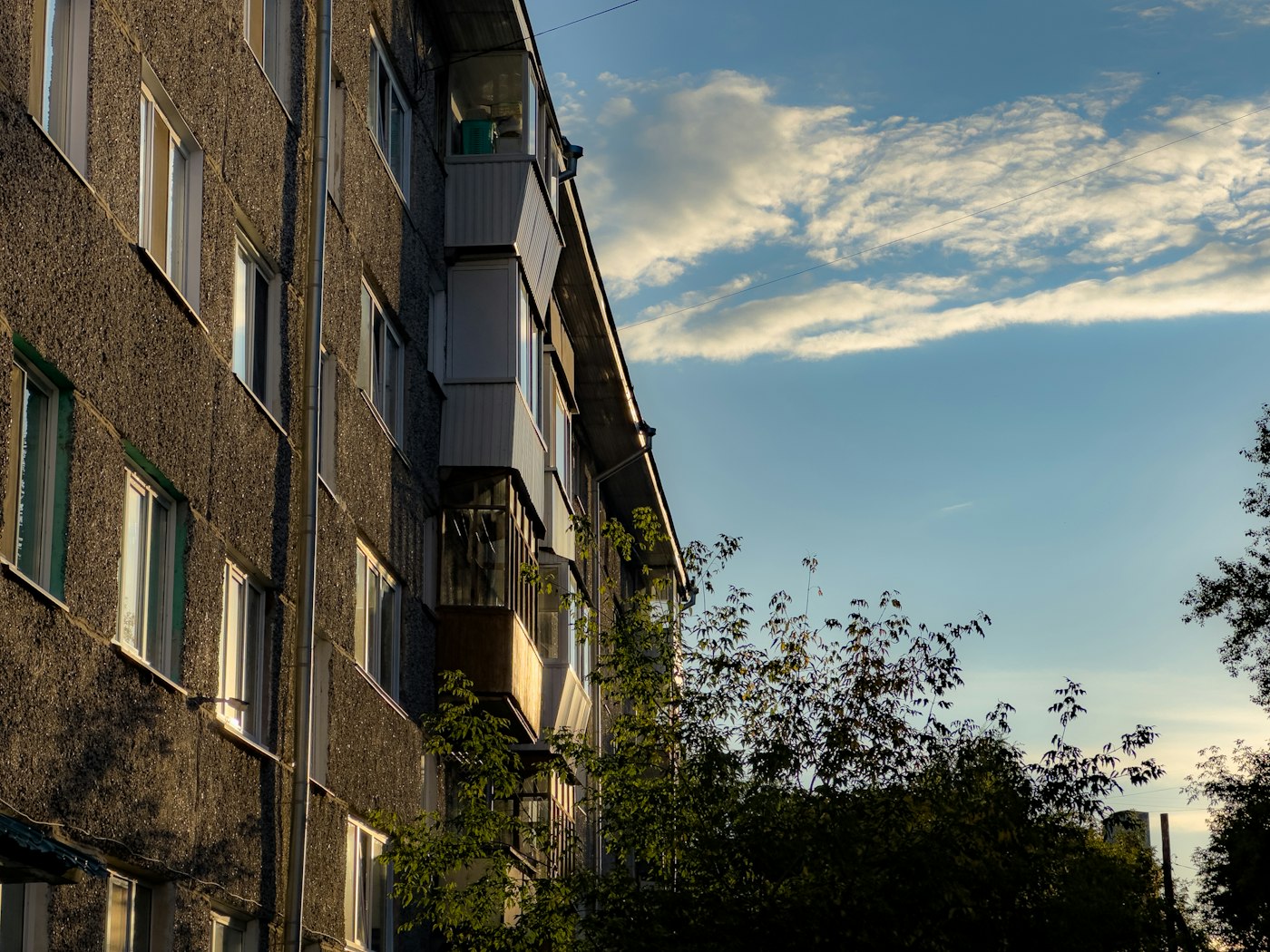Apartment building exterior with trees and sky